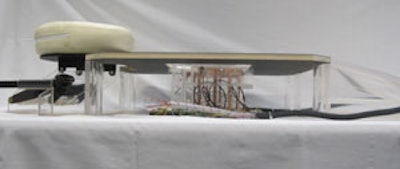 The prototype device showing the cylindrical ladder coil and the patient table with face cushion. The transducer is not shown.