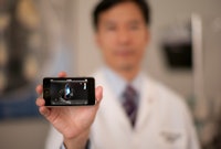 Choi holding an iPhone running echocardiography reading software. By Holger Thoss, courtesy of George Washington School of Medicine and Health Sciences.
