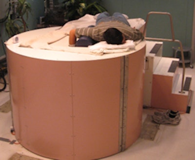 Custom-built extremity PET/CT has a patient lay atop the gantry with his or her hand and arm suspended downward through a hole in the tabletop. All images courtesy of Abhijit Chaudhari, PhD.