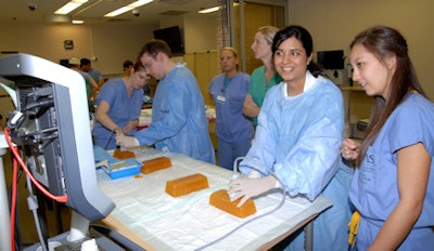 Residents practice ultrasound-guided vascular access using a homemade gelatin phantom. From right along the table: Dr. Megan Long, Dr. Gitanjali Bajaj, Dr. Steven Wright, and Dr. Mollie Meek (instructor). Image courtesy of the University of Arkansas for Medical Sciences.