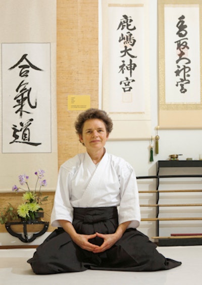 Dr. Myriam Hunink, PhD, meditates in her aikido clothes in the dojo.