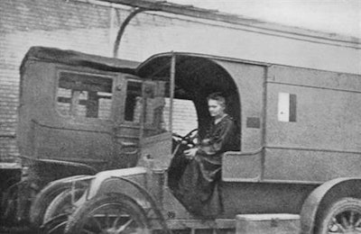 Marie Curie in one of her mobile x-ray units in October 1917. Image from Wikimedia Commons.