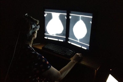 A radiologist outfitted with a head-mounted eye-tracking device examines a mammogram. Image courtesy of Hong-Jun Yoon/Oak Ridge National Laboratory, U.S. Department of Energy.