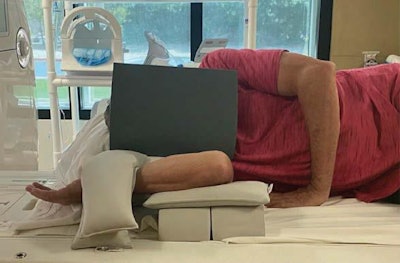 Note elevated flexed elbow and sandbags to induce valgus stress. Elbow coil is not included in image. Image courtesy of the American Roentgen Ray Society.