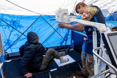 Sergeant Lewis attends a patient in Turkey injured in a recent earthquake. Image courtesy of the British Army.