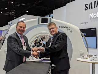 Renaud Maloberti, vice president and head of mobile CT business at NeuroLogica, receives the 2023 Minnie for Best New Radiology Device from AuntMinnie.com Editor-in-Chief Erik Ridley. NeuroLogica was awarded the Minnie for its BodyTom 64 point-of-care mobile CT scanner.