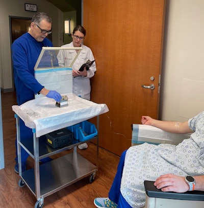 Team members from the theranostics clinic under University of Texas Health Science Center at San Antonio's Department of Radiology show one aspect of a Pluvicto infusion treatment. The L block lead shield over the syringe helps protect certified nuclear medicine technologist James Johnson (left), and nuclear radiologist Penny Vroman, MD (right), from radiation emitted by the drug. (Photo courtesy of UT Health San Antonio Department of Radiology)