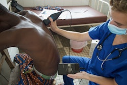 Véronique Suttels, PhD, performs an ultrasound scan on a patient in Benin, West Africa, using a POCUS scanner connected to a smartphone. Her team studied how an AI-guided POCUS system can help diagnose tuberculosis in patients with respiratory symptoms. Image courtesy of Véronique Suttels, PhD.