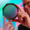 Radiation oncology medical physicist Michael Grams, MD, holds a device called a tungsten collimator that divides a conventional radiation beam into submillimeter-wide beamlets.