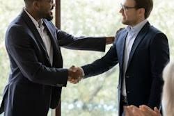 Two businessmen in suits shaking hands during a professional meeting