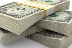 Stacked U.S. dollar bills arranged in piles showing currency denominations