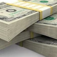 Stacked U.S. dollar bills arranged in piles showing currency denominations