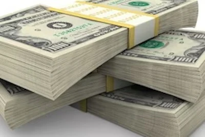 Stacked U.S. dollar bills arranged in piles showing currency denominations