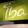 IBA brand logo with white stylized text and circular symbol on green gradient background signage