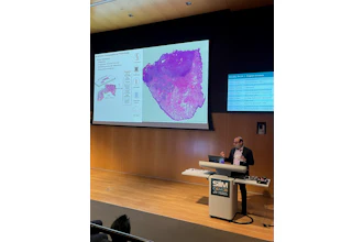 Medical researcher presenting computational pathology findings at SIIM CAIRM26 conference with tissue analysis visualization