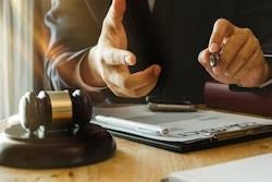 Two professionals reviewing legal documents at a desk with a gavel during a business consultation