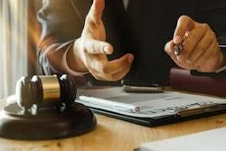 Two professionals reviewing legal documents at a desk with a gavel during a business consultation