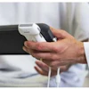 Person holding black smartphone with white charging cable in hands