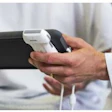 Person holding black smartphone with white charging cable in hands