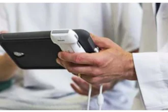 Person holding black smartphone with white charging cable in hands