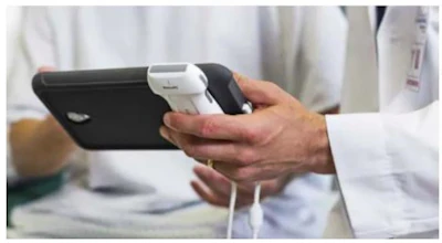 Person holding black smartphone with white charging cable in hands