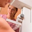 Person smiling while looking in bathroom mirror with towel