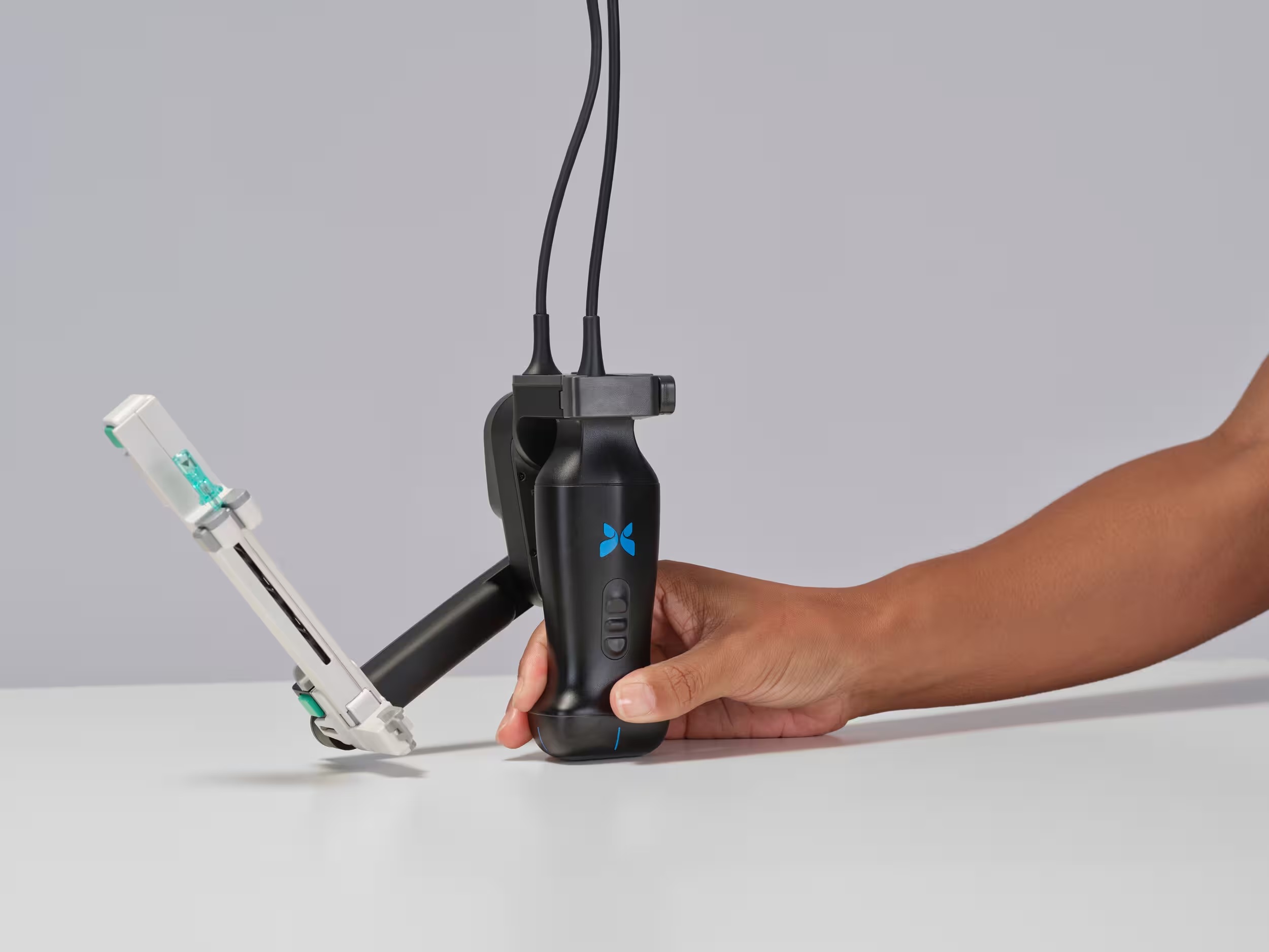 Person holding black handheld dental care device with blue logo and white applicator attachment