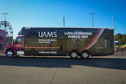 UAMS lung screening mobile unit parked at outdoor venue with Ferris wheel visible in background