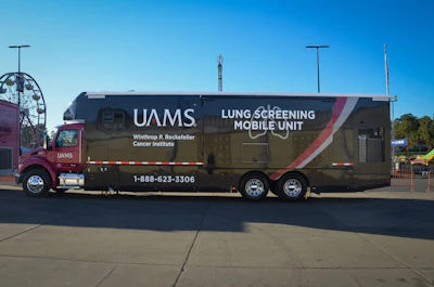 UAMS lung screening mobile unit parked at outdoor venue with Ferris wheel visible in background