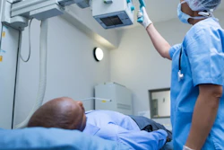 Healthcare provider adjusting medical imaging equipment over patient during diagnostic procedure